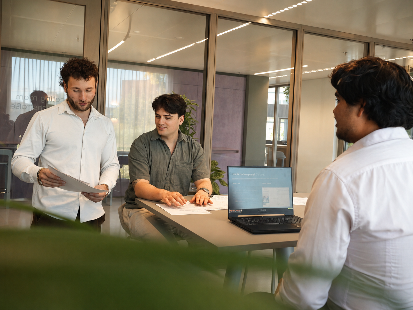 Ris, Dominic en Sean van Velos Marketing bekijken samen documenten tijdens een campagnesessie
