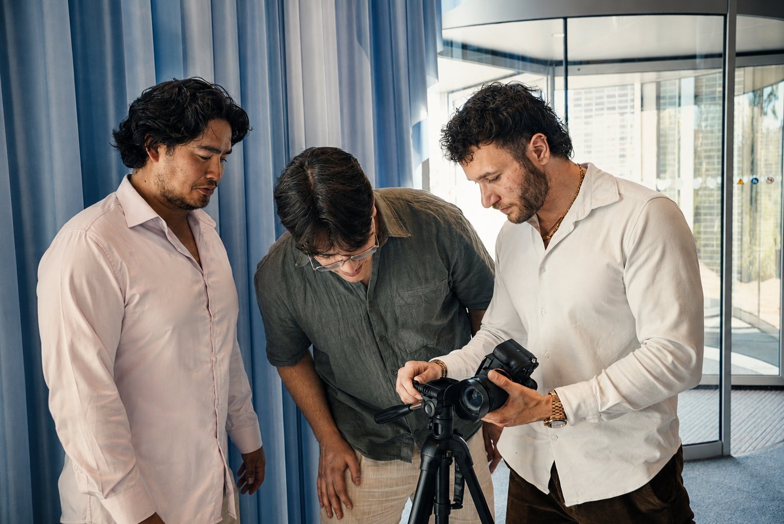 Sean, Dominic en Ris van Velos Marketing beoordelen een camerashot op statief